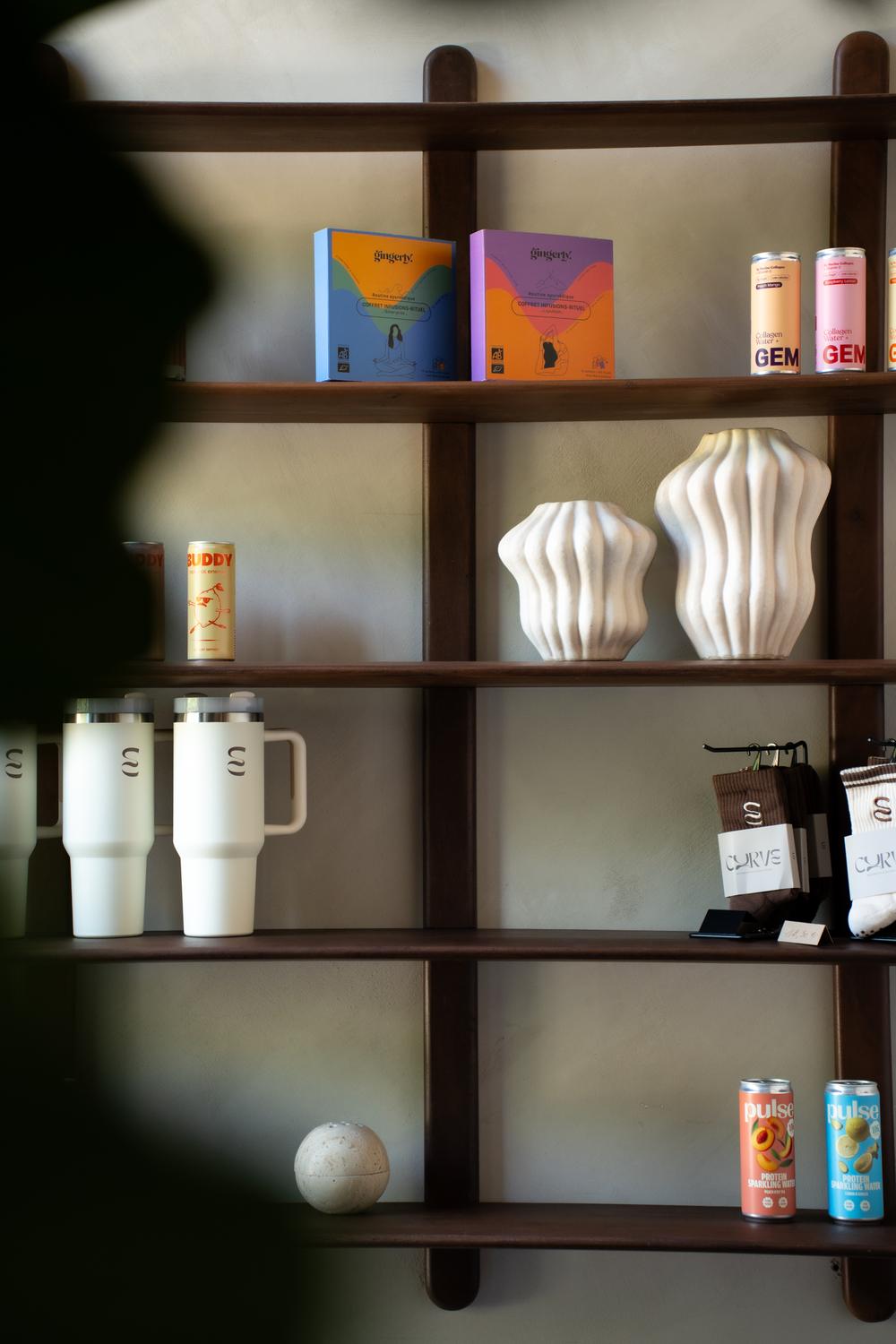 Wooden shelf with Curve tumblers, grip socks and wellness drinks